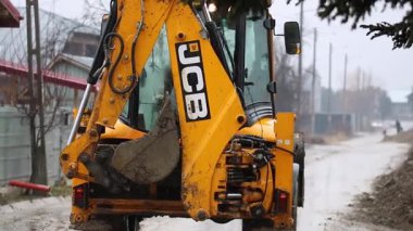 İnşaat alanında kepçe kazıcı. Yol servisi yeni bir cadde inşa etti