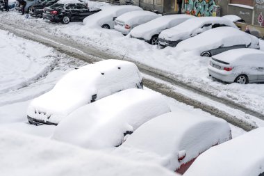 Kar yağdıktan sonra arabalara kar yağar. Kış manzarası ve karla kaplı arabalar