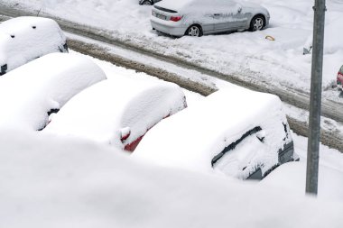 Kar yağdıktan sonra arabalara kar yağar. Kış manzarası ve karla kaplı arabalar