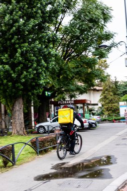 Bisikletli Glovo gıda kuryesi Romanya 'nın Bükreş kentinde yiyecek dağıtıyor