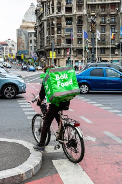 Bisikletli bir Bolt gıda kuryesi Romanya 'nın Bükreş kentinde yiyecek dağıtıyor