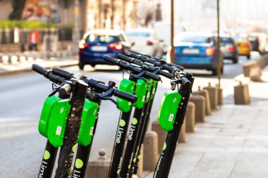 Elektrikli scooterlar şehir merkezine park edilmiş. Dışarıdaki toplu taşıma standı