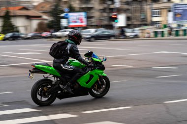 Güneşli bir yaz gününde klasik bir motosiklet caddeye park edilmiş.