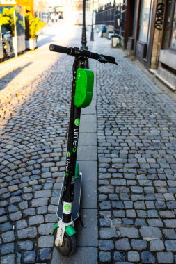 Elektrikli scooterlar şehir merkezine park edilmiş. Dışarıdaki toplu taşıma standı