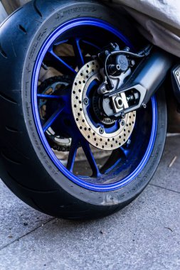 Güneşli bir yaz gününde klasik bir motosiklet caddeye park edilmiş.