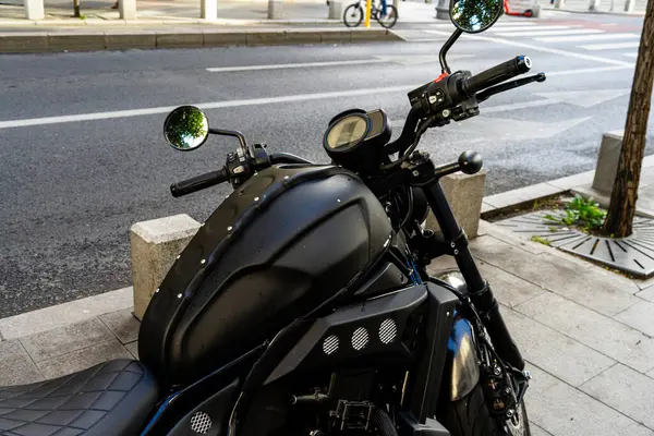 Güneşli bir yaz gününde klasik bir motosiklet caddeye park edilmiş.