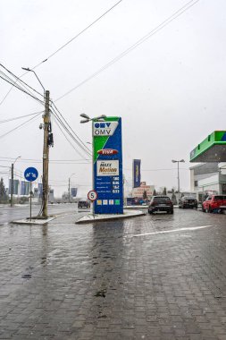 Bir OMV benzin istasyonunun dışı. Benzin pompaları ve arabalar kar yağarken yakıt ikmali yapıyorlar.