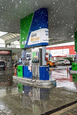 Bir OMV benzin istasyonunun dışı. Benzin pompaları ve arabalar kar yağarken yakıt ikmali yapıyorlar.