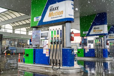 Bir OMV benzin istasyonunun dışı. Benzin pompaları ve arabalar kar yağarken yakıt ikmali yapıyorlar.