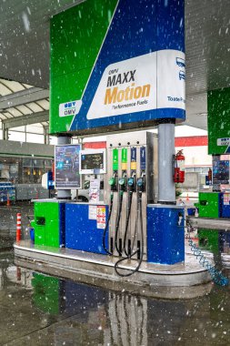 Bir OMV benzin istasyonunun dışı. Benzin pompaları ve arabalar kar yağarken yakıt ikmali yapıyorlar.