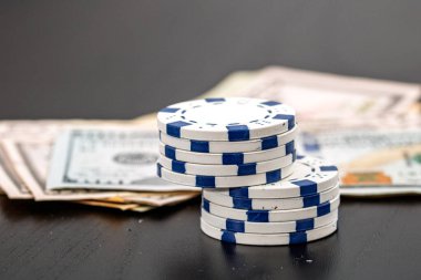 Siyah arka planda parası olan poker fişleri yığını, Amerikan Doları para birimi