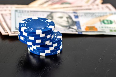 Siyah arka planda parası olan poker fişleri yığını, Amerikan Doları para birimi