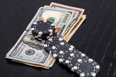 Siyah arka planda parası olan poker fişleri yığını, Amerikan Doları para birimi