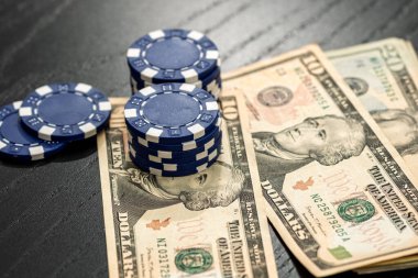 Siyah arka planda parası olan poker fişleri yığını, Amerikan Doları para birimi