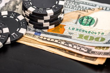 Siyah arka planda parası olan poker fişleri yığını, Amerikan Doları para birimi