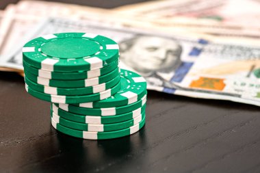 Siyah arka planda parası olan poker fişleri yığını, Amerikan Doları para birimi