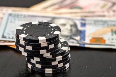 Siyah arka planda parası olan poker fişleri yığını, Amerikan Doları para birimi