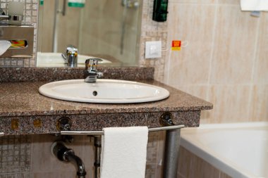 Otel banyosunda lavabo ve havlu.