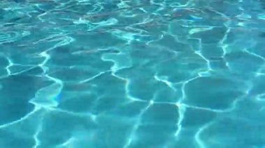 Blue water in the swimming pool with light reflections. Concept of vacation and tranquility