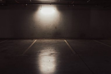 Boş yer altı garajı. Boş park yeri ve loş ışık