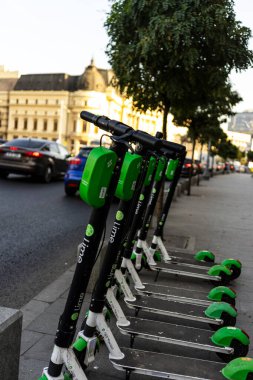 Elektrikli scooterlar şehir merkezine park edilmiş. Dışarıdaki toplu taşıma standı