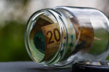 İsviçre frangı CHF banknotu cam kavanozda para biriktiriyor. Tüketim ve ekonomi. İş, bahşiş, finans, tasarruf, bankacılık ve insan kavramı