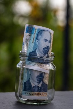 Bulgar LEVA banknotu cam kavanozda para biriktiriyor. Tüketim ve ekonomi. İş, bahşiş, finans, tasarruf, bankacılık ve insan kavramı