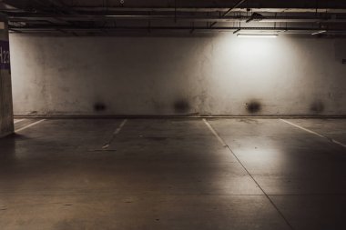 Boş yer altı garajı. Boş park yeri ve loş ışık