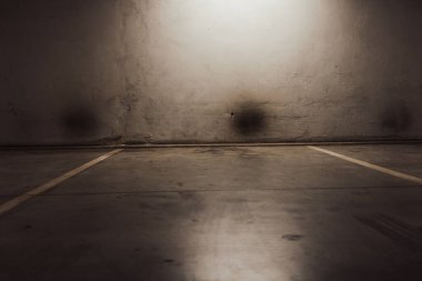 Boş yer altı garajı. Boş park yeri ve loş ışık