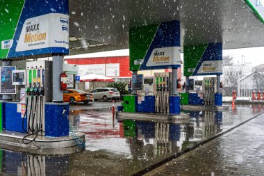 Bir OMV benzin istasyonunun dışı. Benzin pompaları ve arabalar kar yağarken yakıt ikmali yapıyorlar.