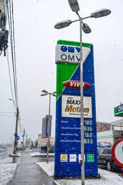 Bir OMV benzin istasyonunun dışı. Benzin pompaları ve arabalar kar yağarken yakıt ikmali yapıyorlar.