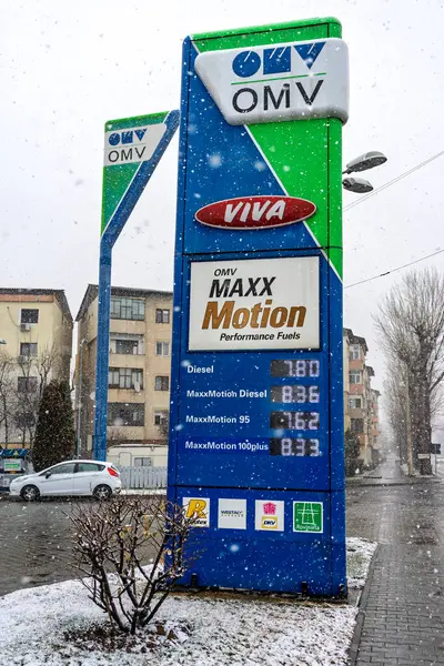 Bir OMV benzin istasyonunun dışı. Benzin pompaları ve arabalar kar yağarken yakıt ikmali yapıyorlar.