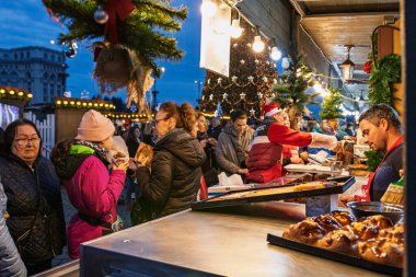 Bükreş Noel Pazarı 'nda insanlar eğleniyor ve yemek yiyor.