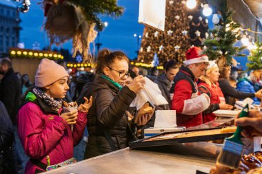 Bükreş Noel Pazarı 'nda insanlar eğleniyor ve yemek yiyor.