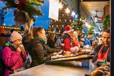 Bükreş Noel Pazarı 'nda insanlar eğleniyor ve yemek yiyor.
