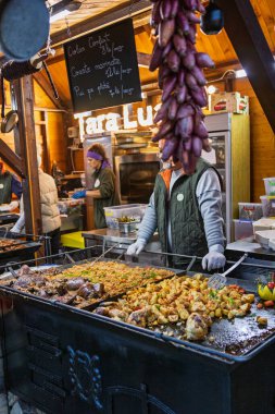 Bükreş Noel Pazarı 'nda insanlar eğleniyor ve yemek yiyor.