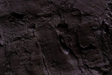 İnşaat alanındaki bir duvardaki taze beton darbelerin dokusu. Koyu arkaplan.