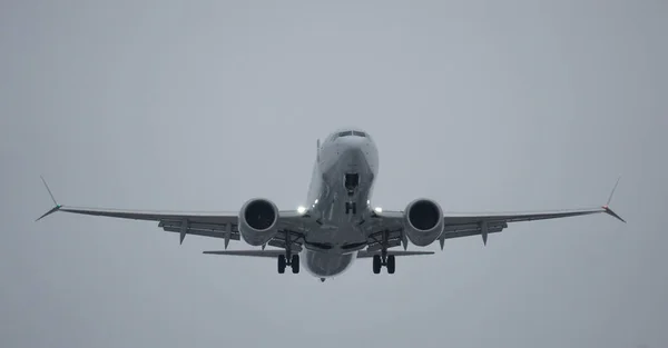 Looking up at a Boeing 737 flying overhead as it approaches the airport.