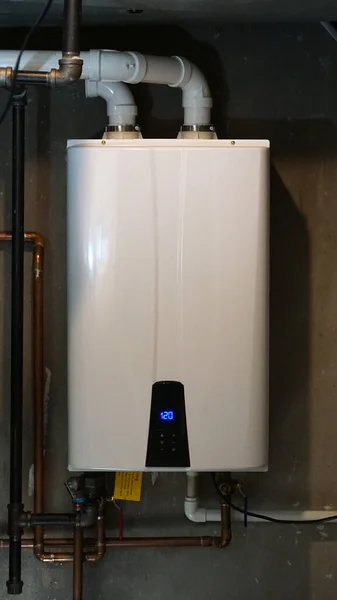 stock image Tankless hot water heater installed in a home's boiler room.