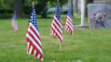 Bir savaş anıtı plaketinin yakınına Amerikan bayrakları dikildi..