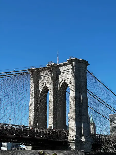 Brooklyn Köprüsü 'nün kulesi ve onun kablosu açık mavi gökyüzüne karşı.