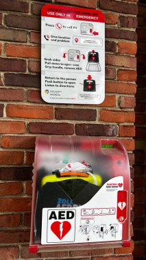 Oak Park, IL, ABD - 15 Temmuz 2023: Otomatik Harici Defibrilatör bir kamu parkı tesisinin tuvaletinin önüne kuruldu. AED 'ler doğrudan 911' e bağlı.