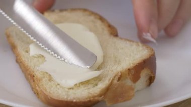 Buğday dilimine tereyağı sürüyorum. Yüksek kalite 4k görüntü