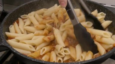 Ev yapımı ragu alla bolonez hazırlıyorum. Makarnayı ince dilimlenmiş domates sosuyla kızartma tavasında karıştırıyorum..