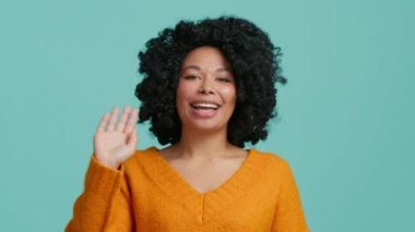 Genç mutlu Afrikalı Amerikalı karışık ırk hipster vlogger kadın el sallayarak web kamerasına bakıyor izole edilmiş arka planda kameraya konuşuyor sosyal mesafe arkadaşıyla sanal sohbet görüşmesi çağrısında bulunuyor.