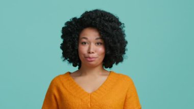 Sevimli, Afro-Amerikan kadın kalp işareti gösteriyor. Minnettar gülümseme, izole arkaplana bakıyor. Aşk desteği, gönüllülük, bağış, iyilik kavramını kapat.