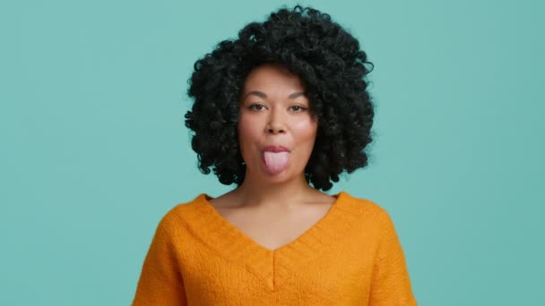 快乐有趣的非洲裔美国女人 卷曲的头发 在镜头前做鬼脸 鬼鬼祟祟的 慢动作4K独立演播室背景的漂亮女模特 — 图库视频影像