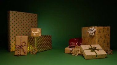 Parlak yeşil ve gümüş desenli Kraft kağıdında güzel hediyeler yığını. Ticari mesaj arkaplanı için sinematik çekim ve satış kopyası veya tanıtım metni için merkez alan