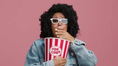 Korkak kadın yüksek sesle bağırıyor. Movie Plot Efektleriyle Akıl Uçurma. 3D TV 'de korku filmlerinden dehşete düşmüş, kontrolsüz bir şekilde patlamış mısır yiyen komik Afrikalı Amerikalı genç bir kadının portresi.