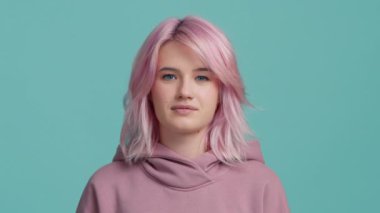 Sakin öğrenci kız başını sallayarak bunun doğru olduğunu söylüyor. Olumlu gülümseyen genç hippi model seninle aynı fikirde. Moda pastel, pembe saç stili, kapüşonlu, izole bir arka planı olan bir kadın.